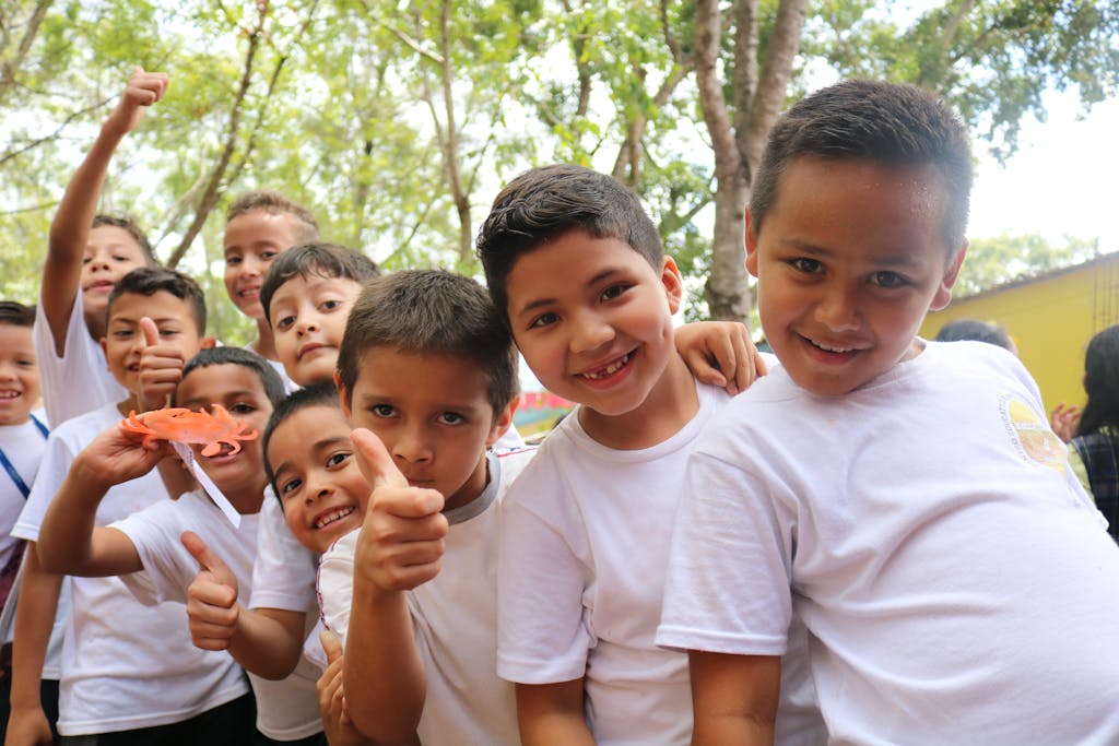 Group of Children Wearing White Crew Neck T-shirts Smiling at Camera