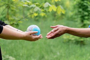 Hands Passing the Globe to the Person